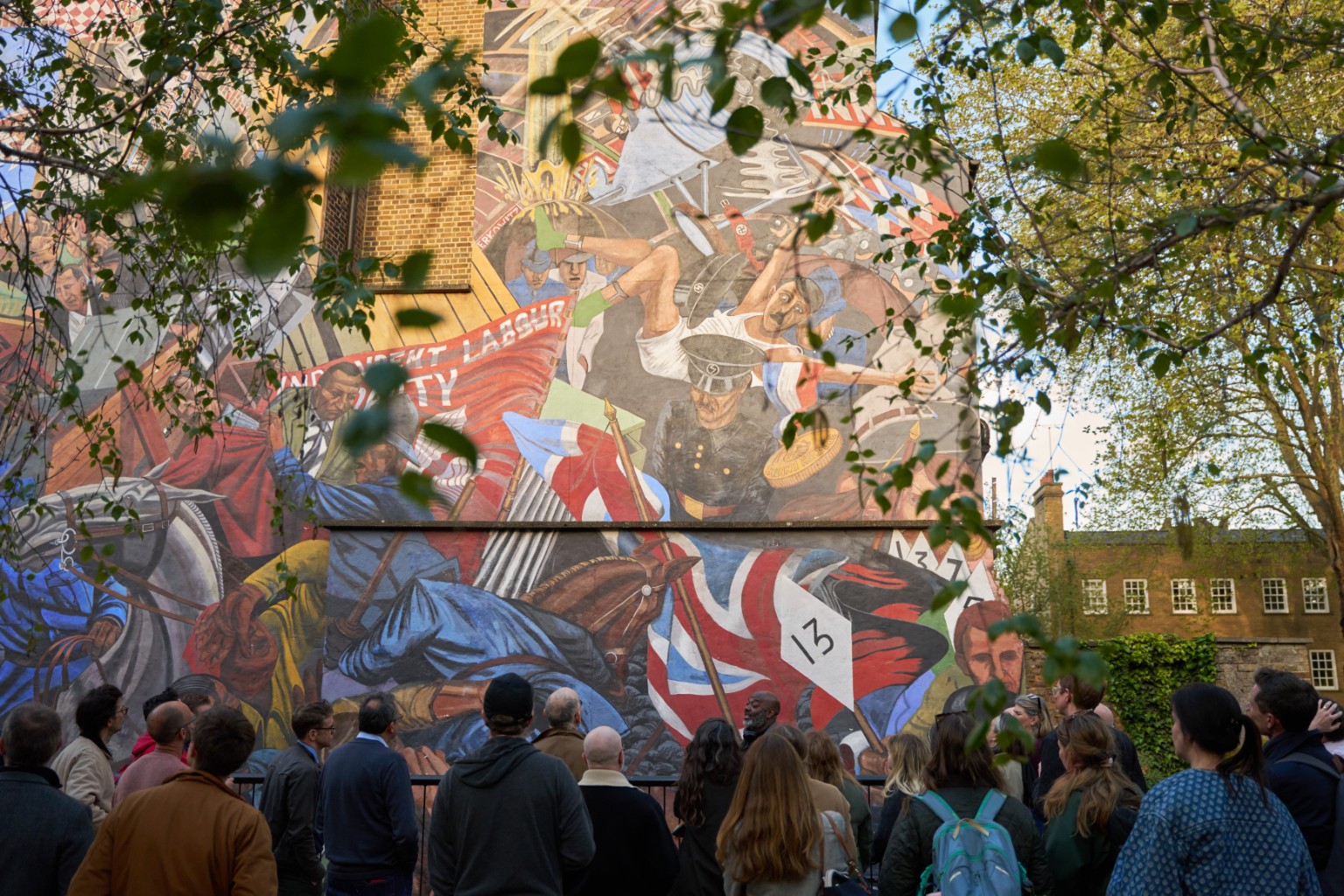An Agora group gathered in front of a colourful London mural